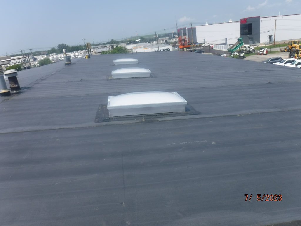 Commercial flat roof surface with rooftop skylights.